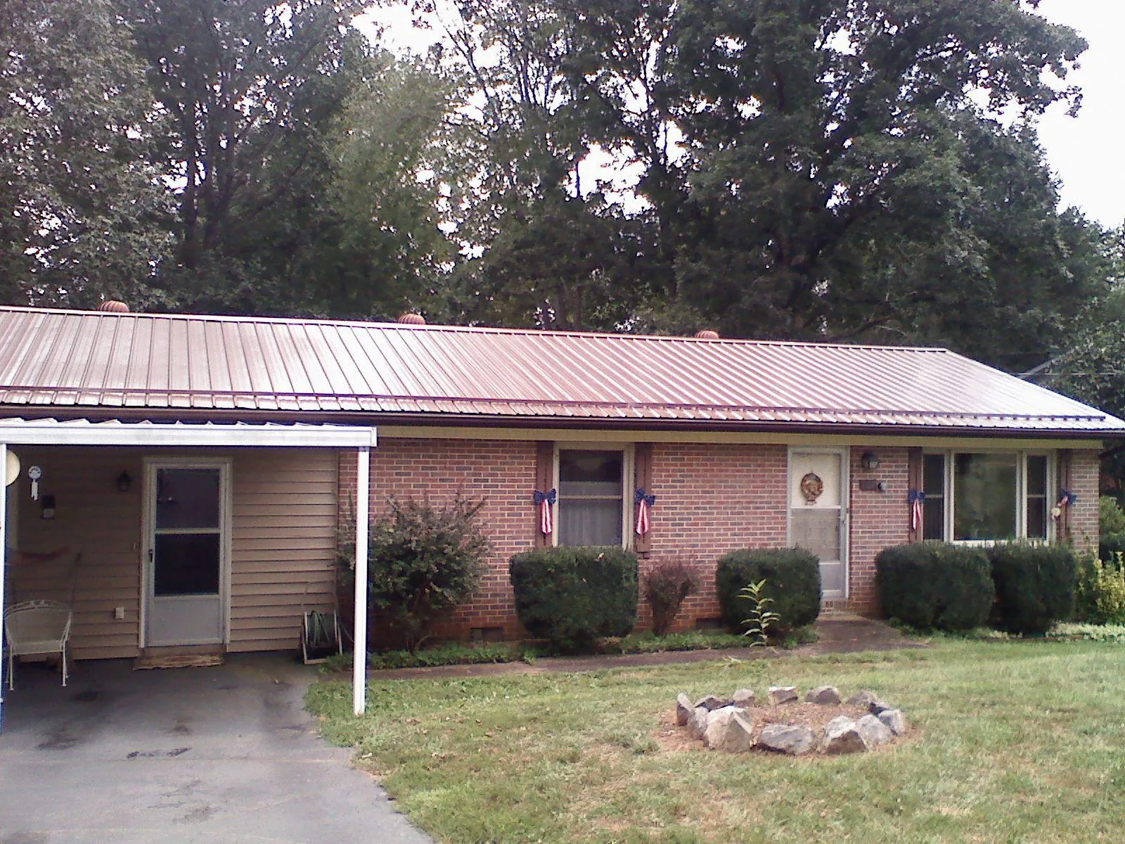Bronze metal roof and carport on a brick ranch home — Roof Repair work by our crew in Ipswich